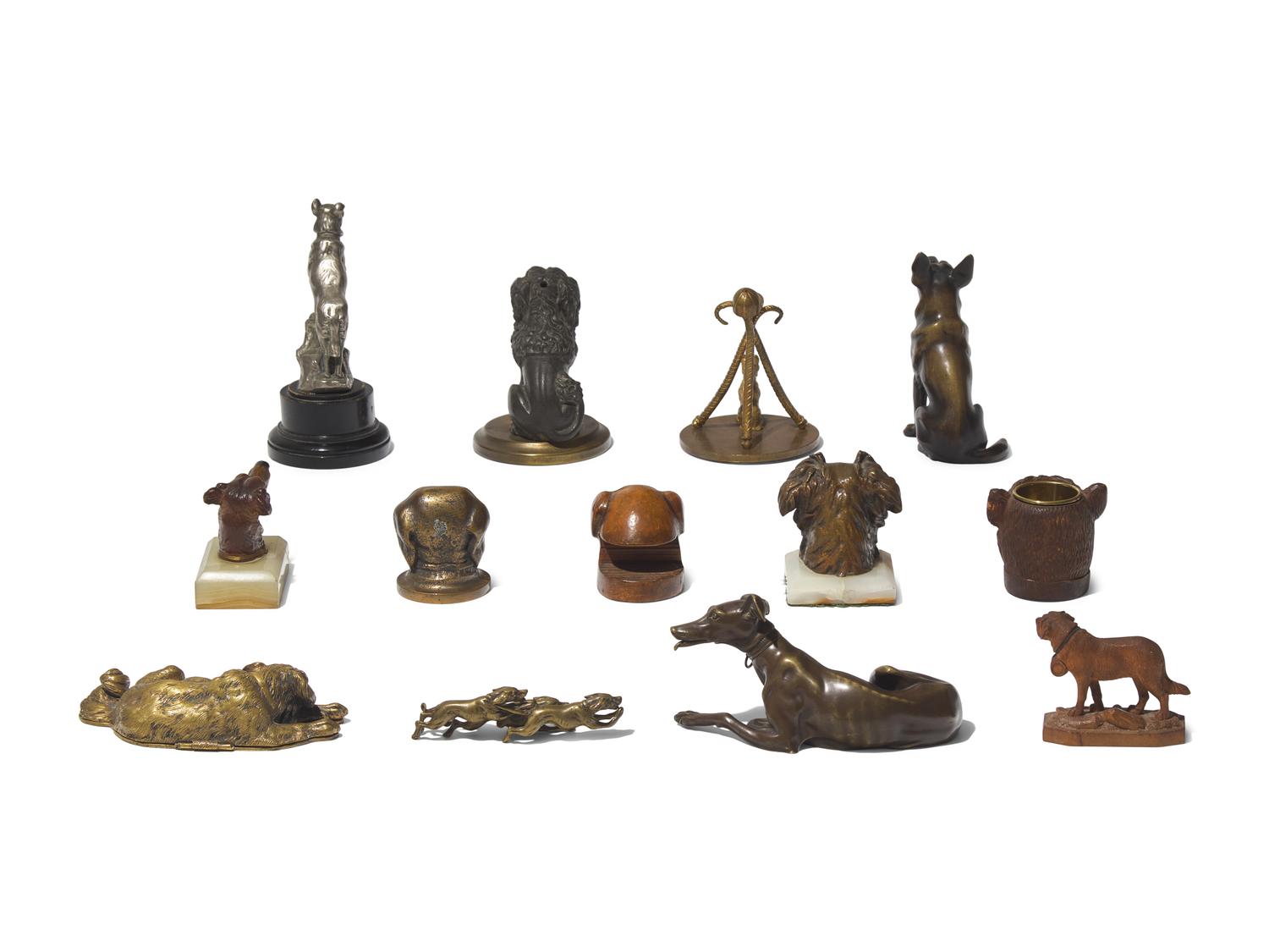 A Collection of Thirteen Cast Metal and Carved Wood Dog Figures and Articles