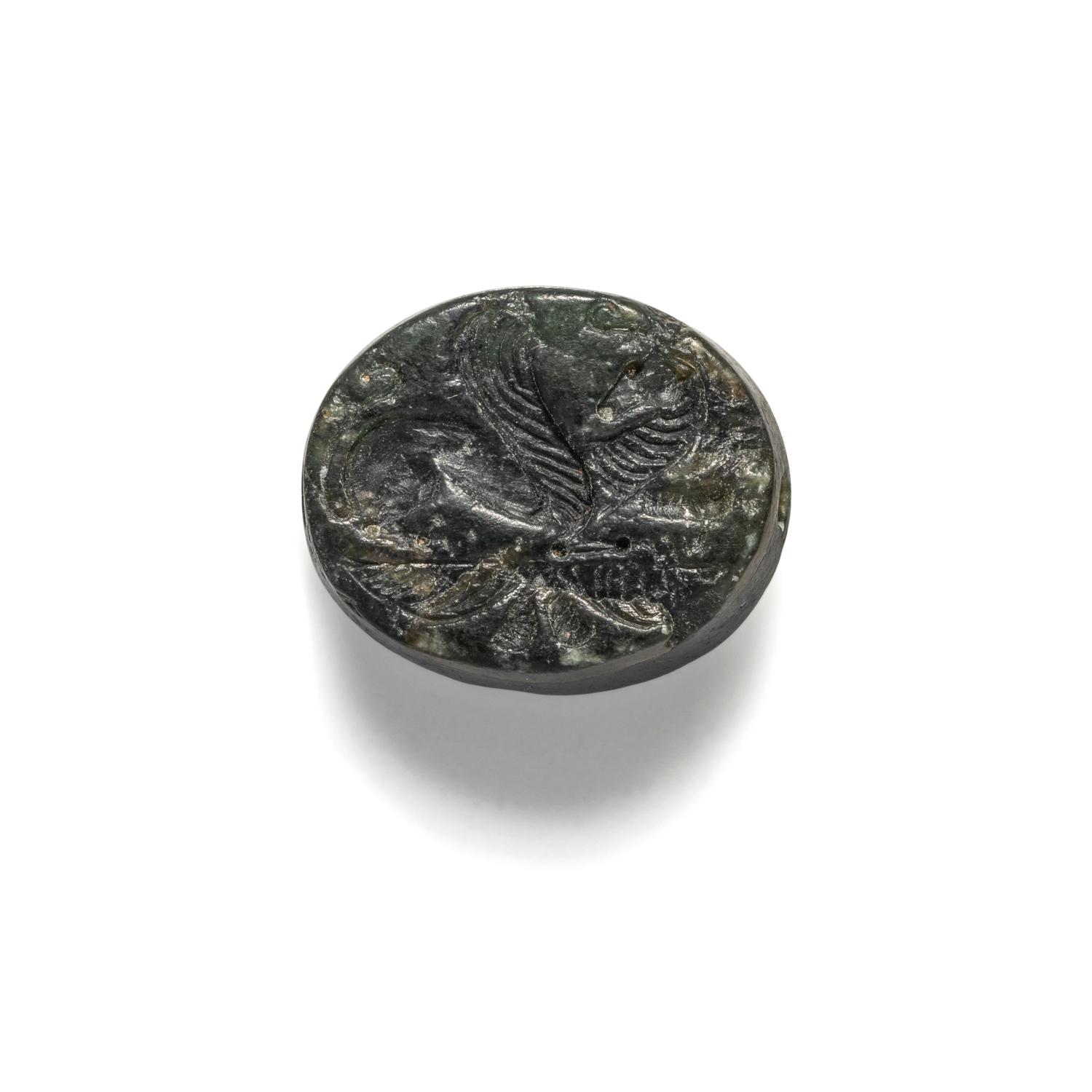 A Greco-Persian Onyx Scaraboid with a Griffin and Winged Sun Disc
