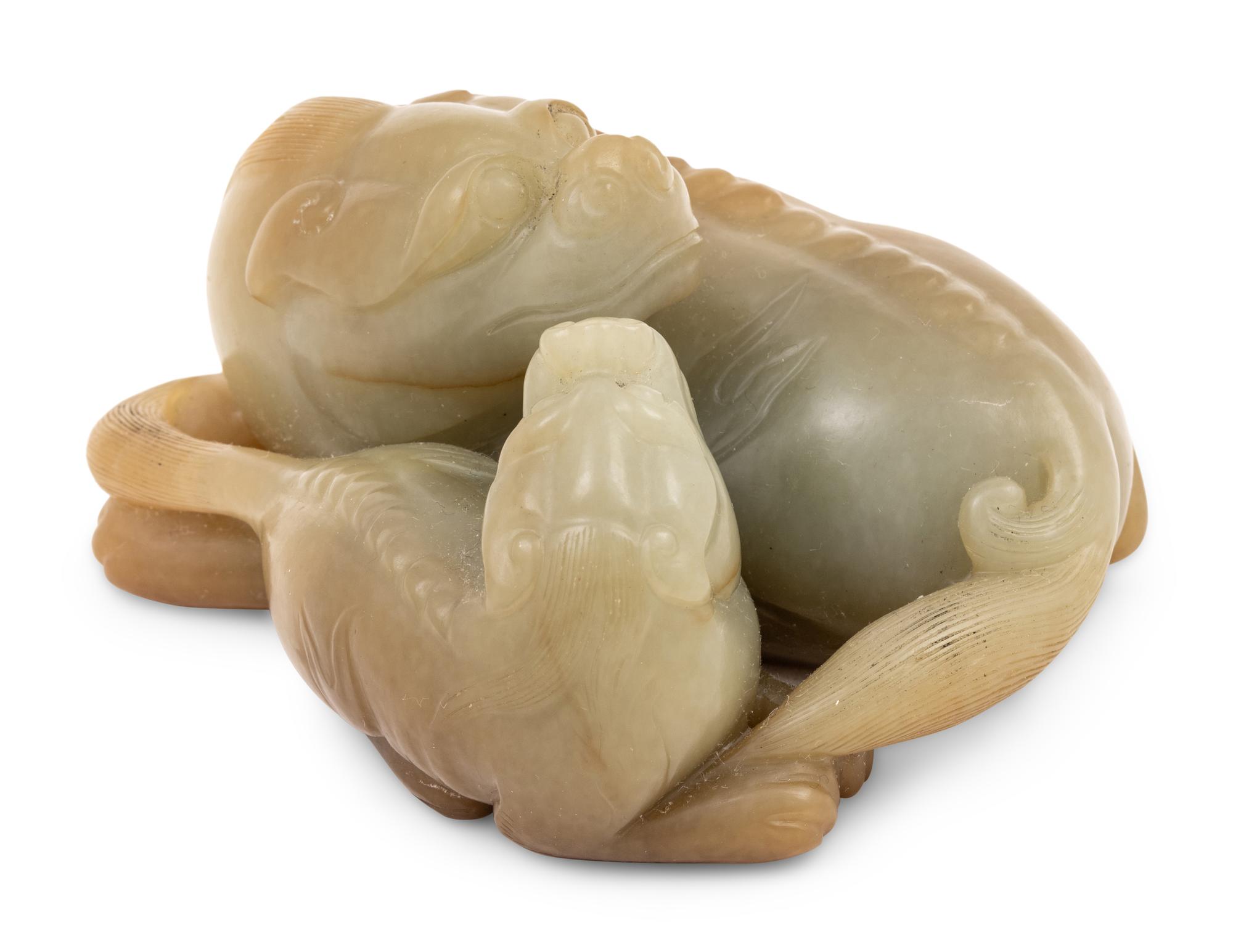 A Chinese Celadon and Russet Jade Carving of Two Mythical Beasts