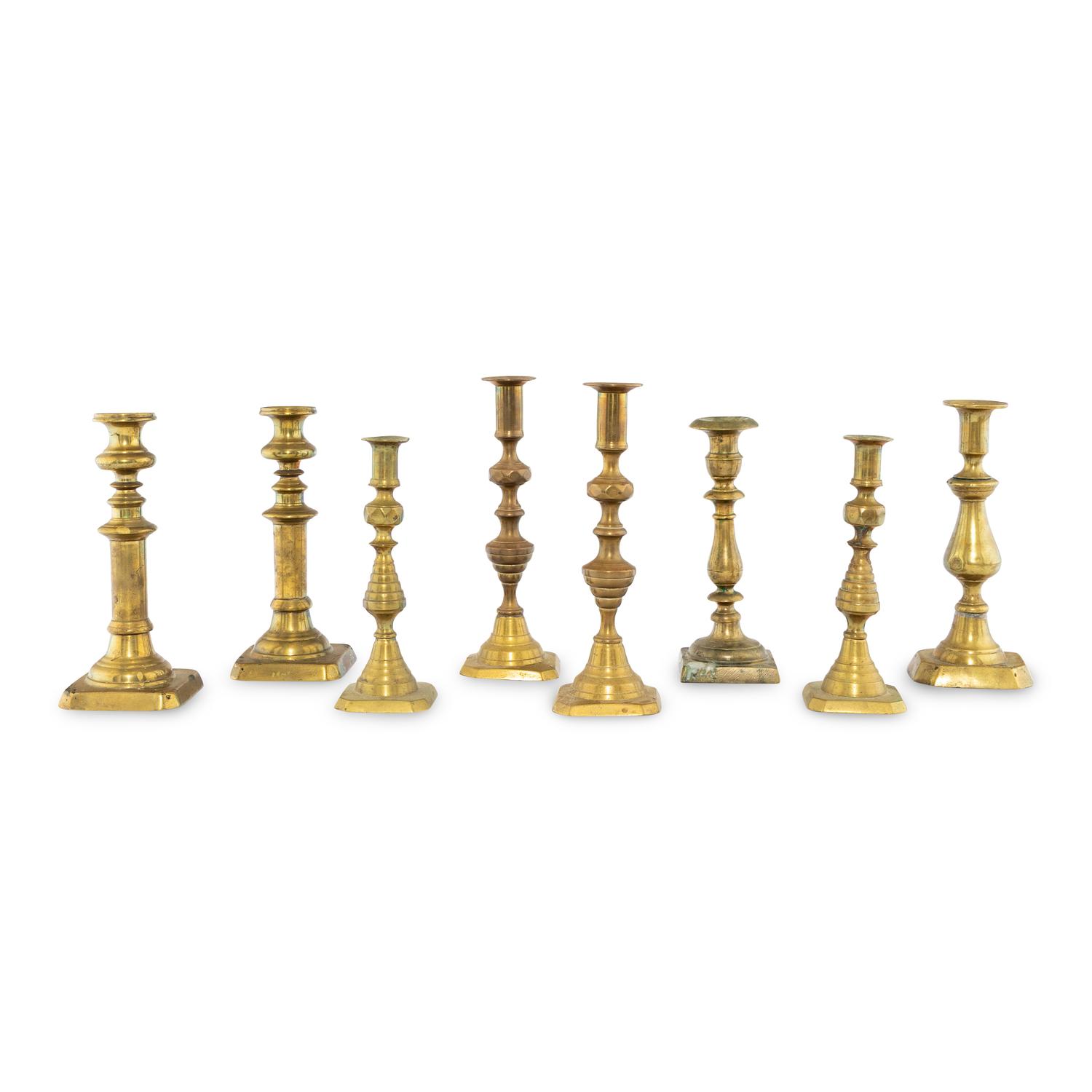 A Collection of Eight Continental Brass Candlesticks