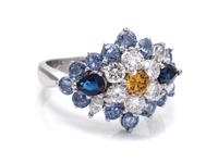 An 18 Karat White Gold, Colored Diamond, Diamond and Sapphire Ring,