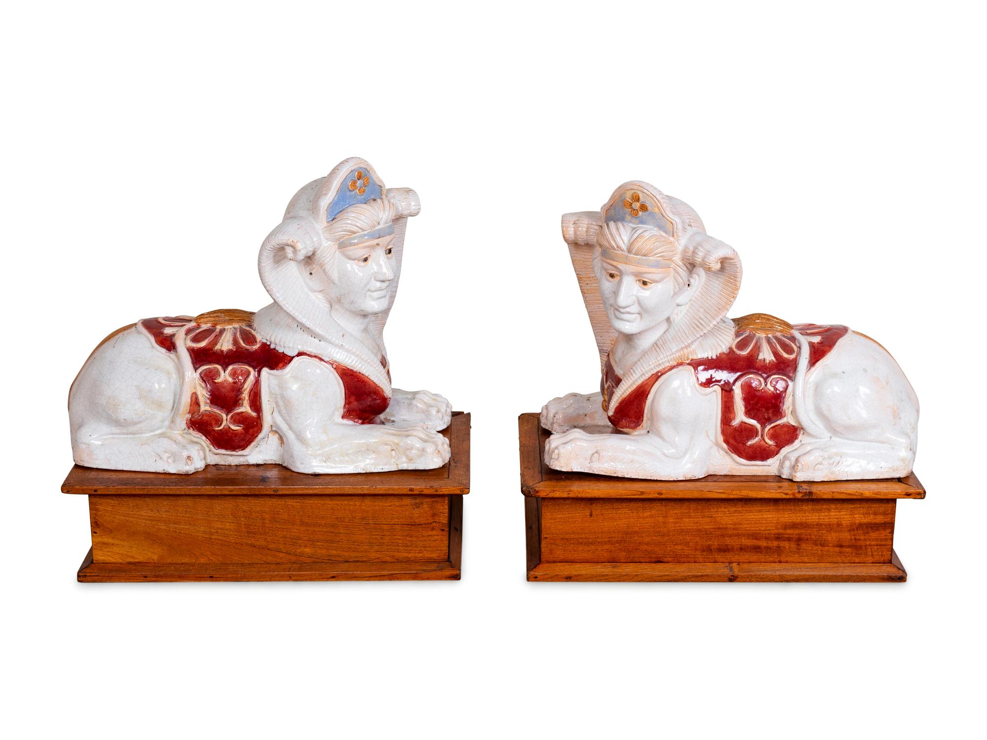 A Pair of Polychromed Ceramic Sphinxes — 20TH CENTURY