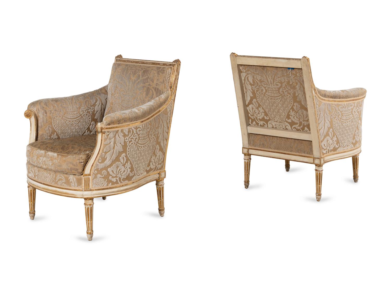 A Pair of Louis XVI Cream-Painted and Parcel Gilt Bergères