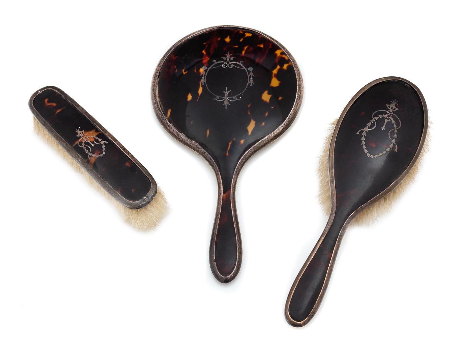 An English Silver and Tortoise Shell Three-Piece Dresser Set, G. W. Lewis & Co., Birmingham, 1919-25, comprising two brushes and a hand