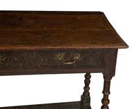 A Jacobean Style Carved Oak Writing Table and a Similar Stool with Flip Top