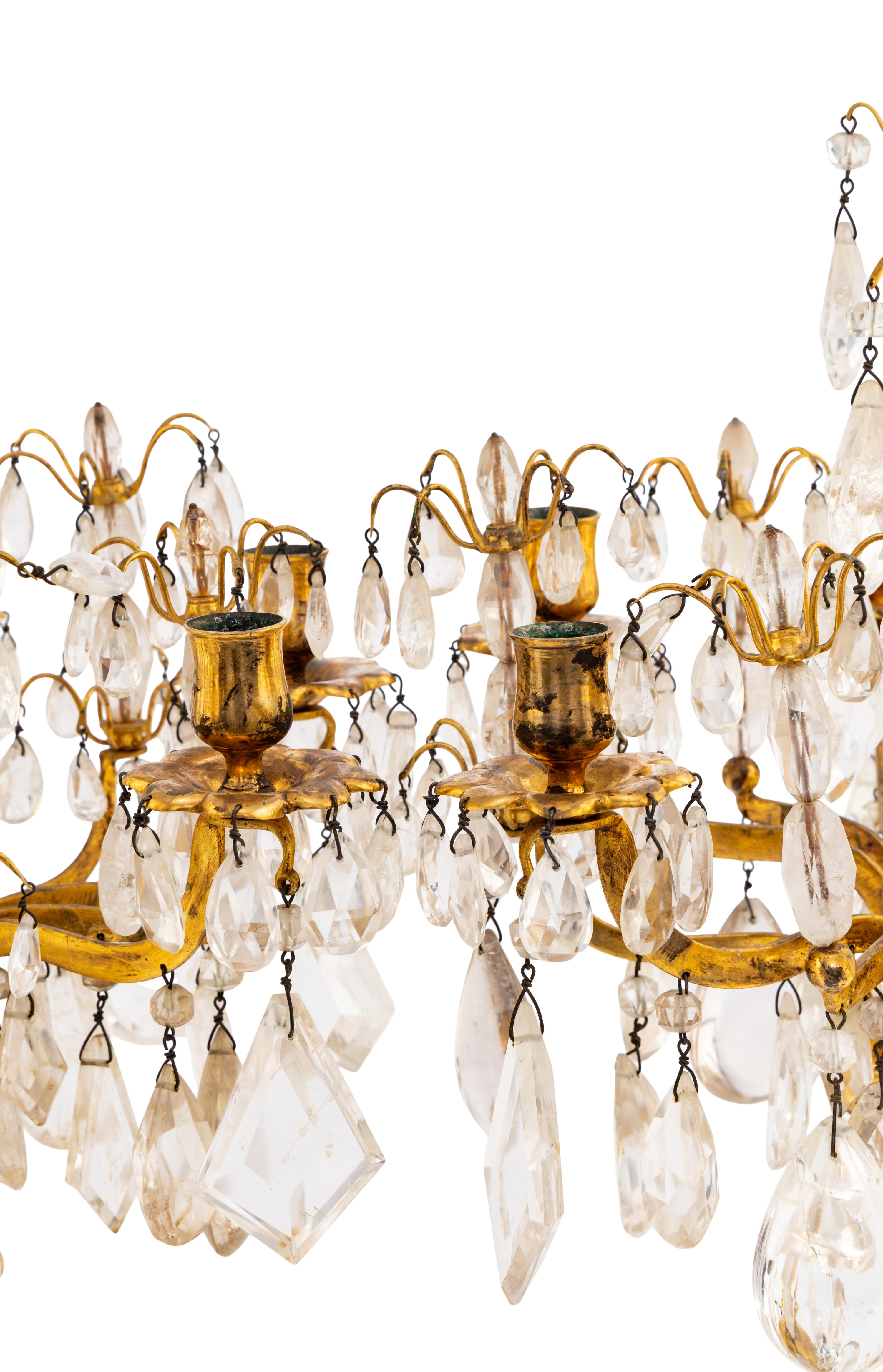 A Pair of Régence Style Rock Crystal, Cut Glass and Engraved Gilt Bronze Six-Light Candelabra on Simulated Porphyry Bases