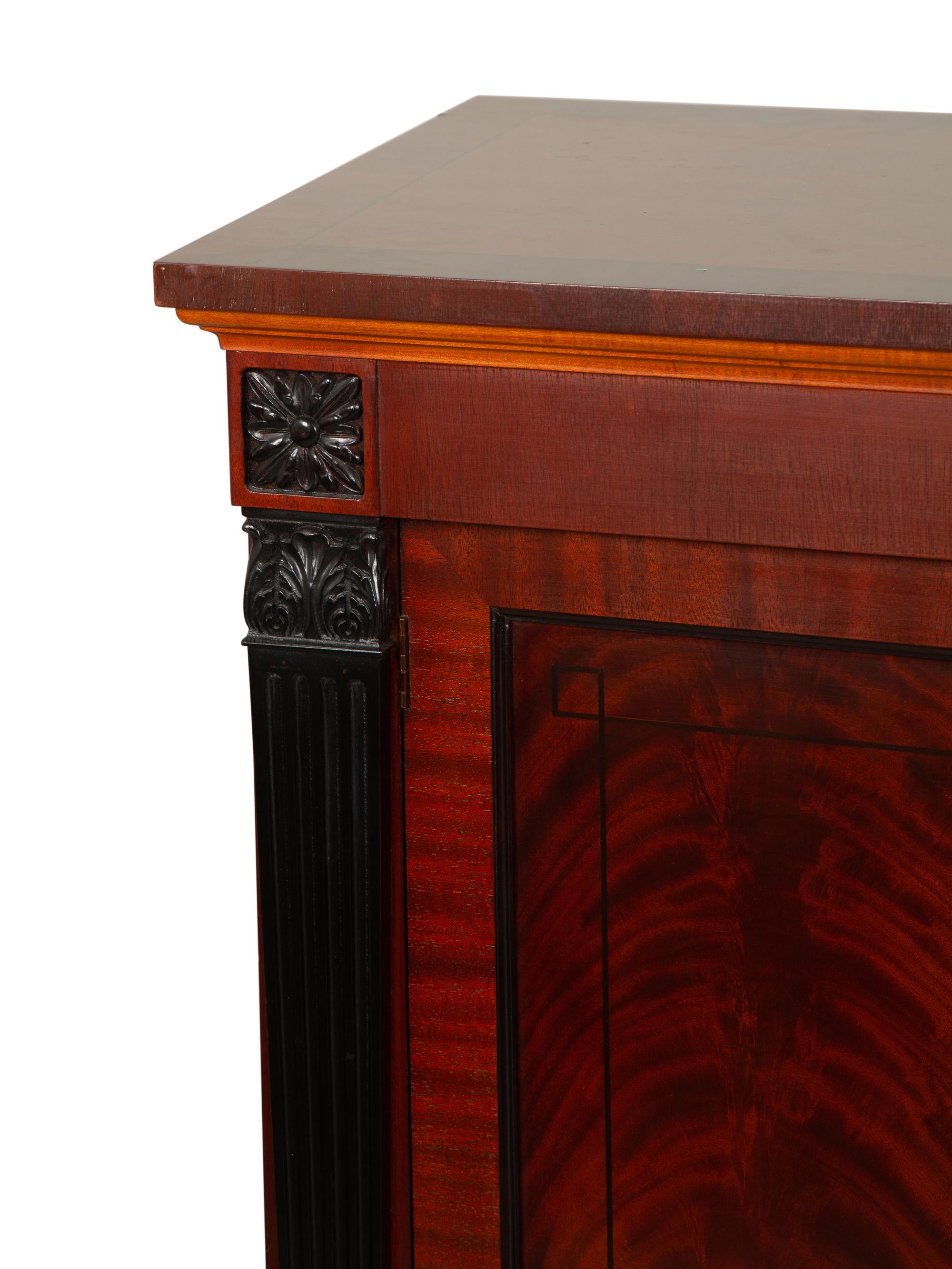 A Late Regency Style Figured Mahogany Sideboard with Carved Ebonized Pilasters