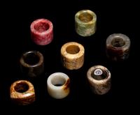 A Group of Chinese Jade and Hardstone Archers Rings with an Embroidered Silk Case