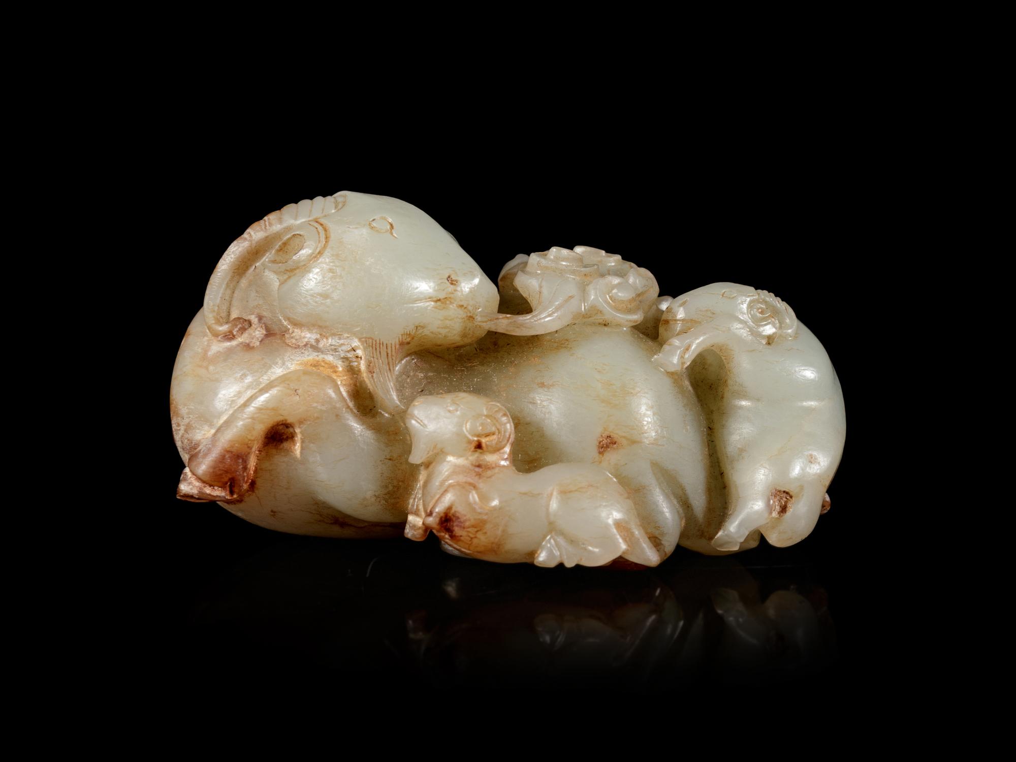 A Carved Celadon and Russet Jade 'Three Rams' Group