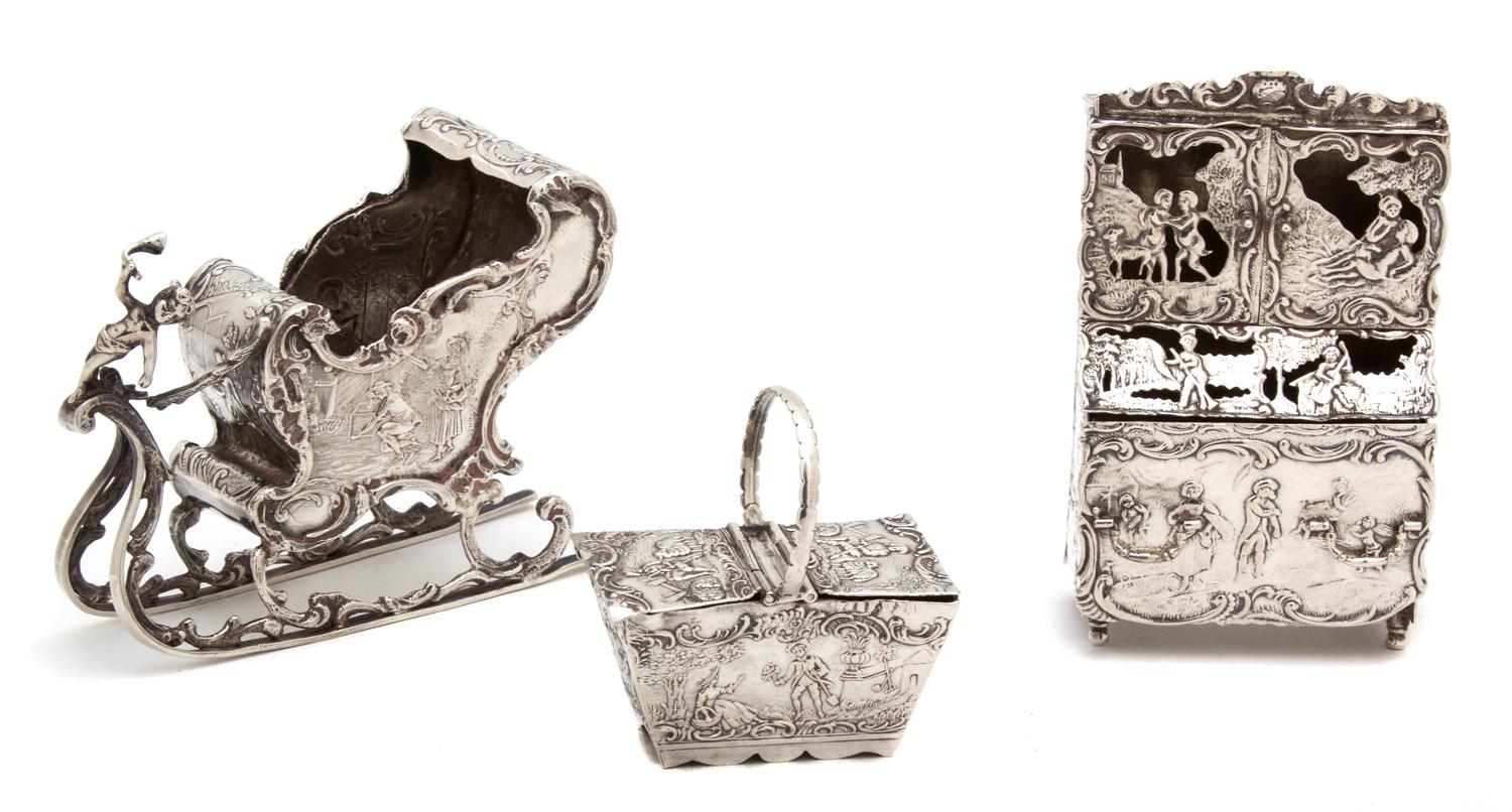 Three Continental Silver Ornaments, Possibly German, 19th Century, comprising a sleigh, a cabinet, and a basket
