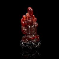 A Chinese carved amber figure of a sage and acolytes