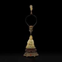 A Chinese carved mottled celadon jade figure of Guanyin, mounted as a lamp 玉雕观音改装台灯