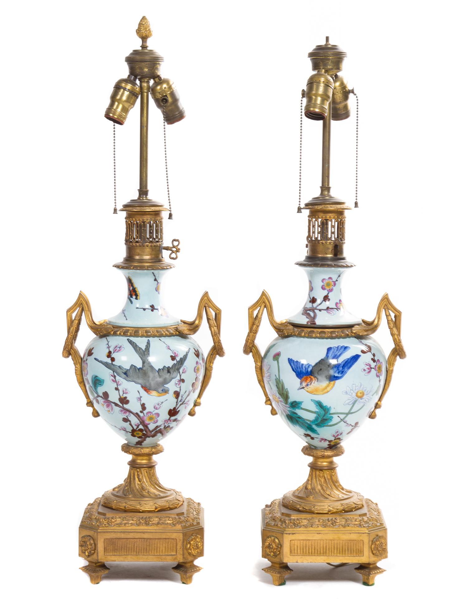 A Pair of French Gilt Bronze Mounted Ceramic Urns Height overall 31 inches.