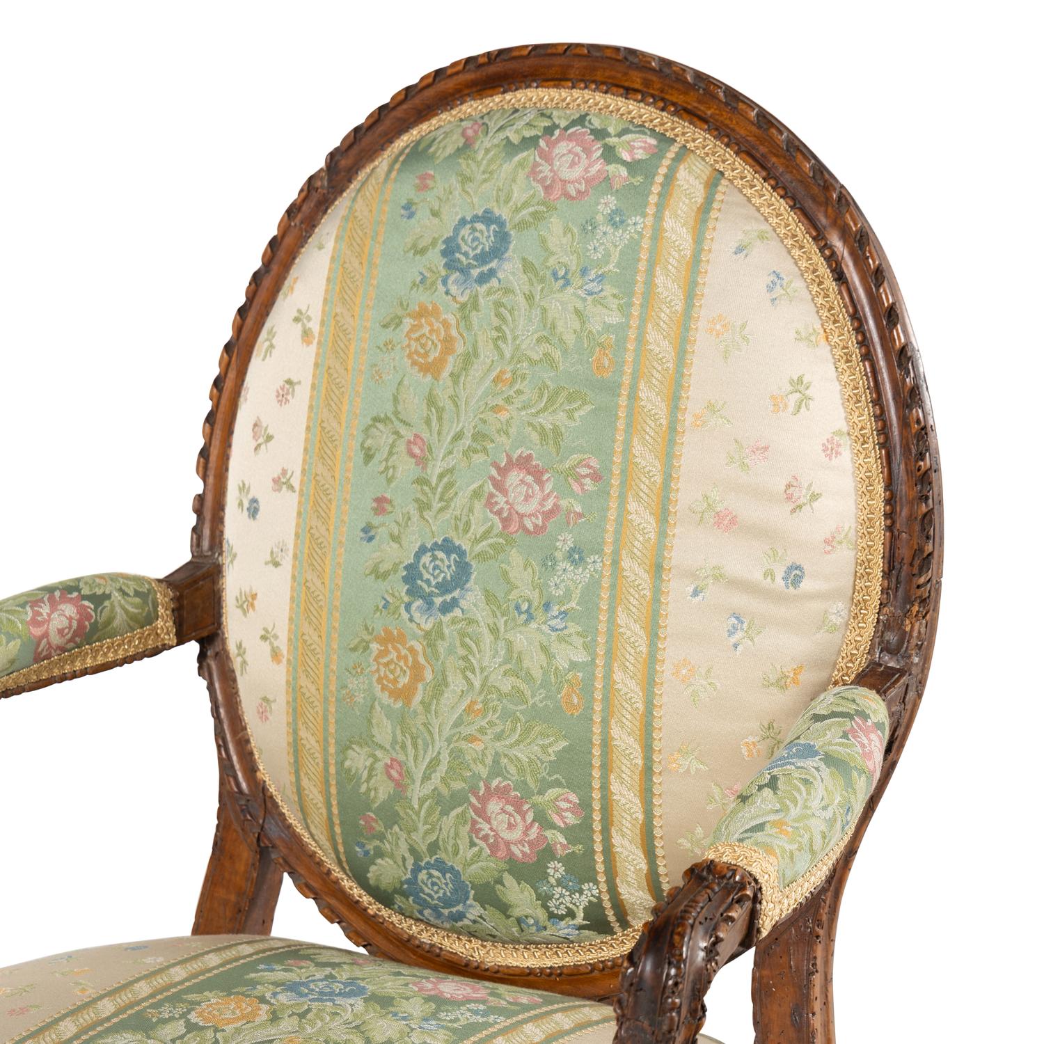 A Pair of Louis XVI Carved Walnut Fauteuils