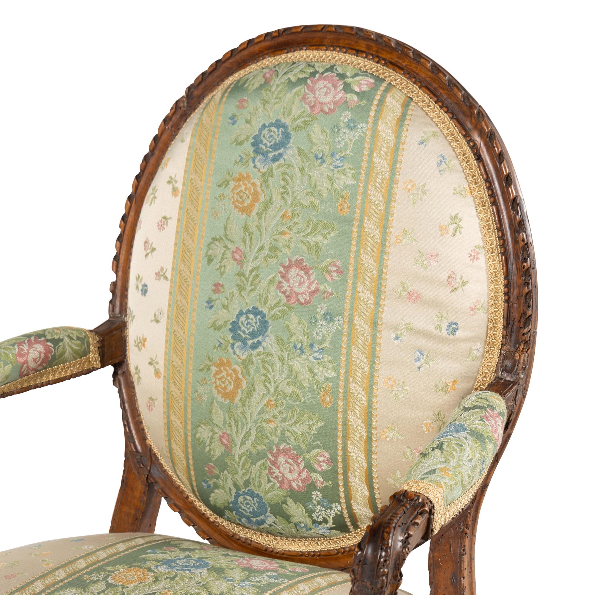 A Pair of Louis XVI Carved Walnut Fauteuils