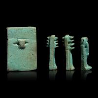 An Egyptian Faience Amulet with the Osirian Triad, two Djed Pillars, and a Thoth Amulet