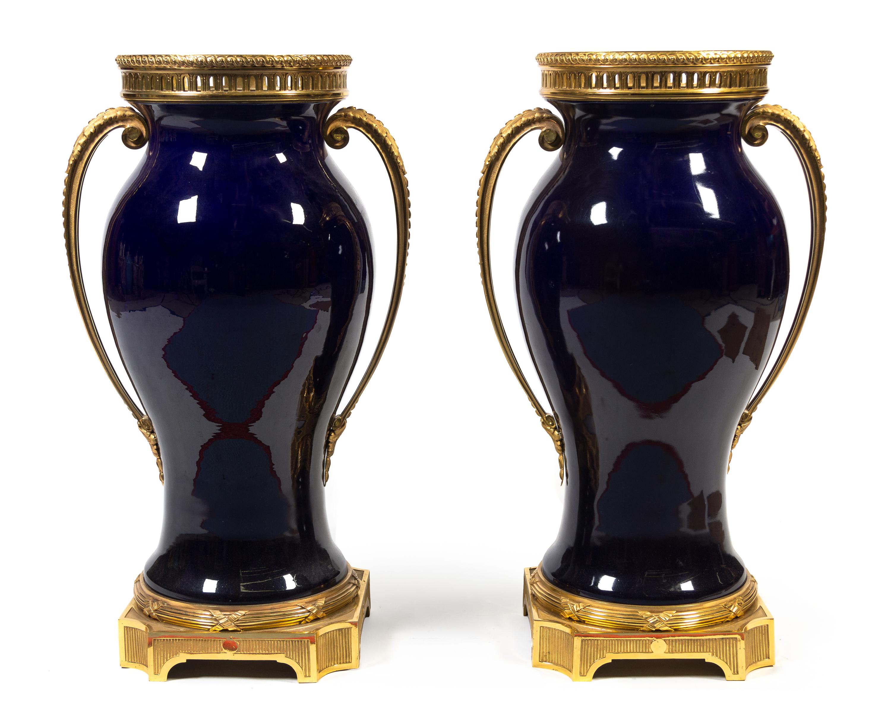 A Pair of French Gilt Bronze Mounted Cobalt Glazed Ceramic Urns Height 33 inches. — 20TH CENTURY