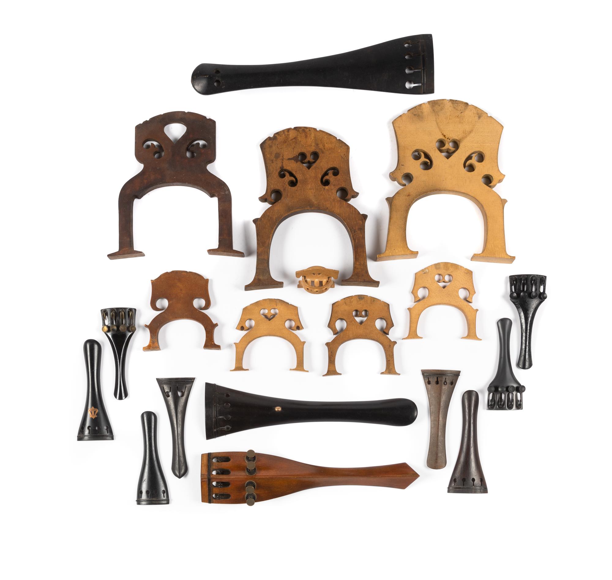 A Group of Stringed Instrument Parts Including Tailpieces and Bridges