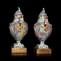 A Pair of Chinese Export Canton Famille Rose Porcelain Covered Urns, Early 19th Century — 清晚期 外銷廣彩人物故事圖獎杯形賞瓶一對