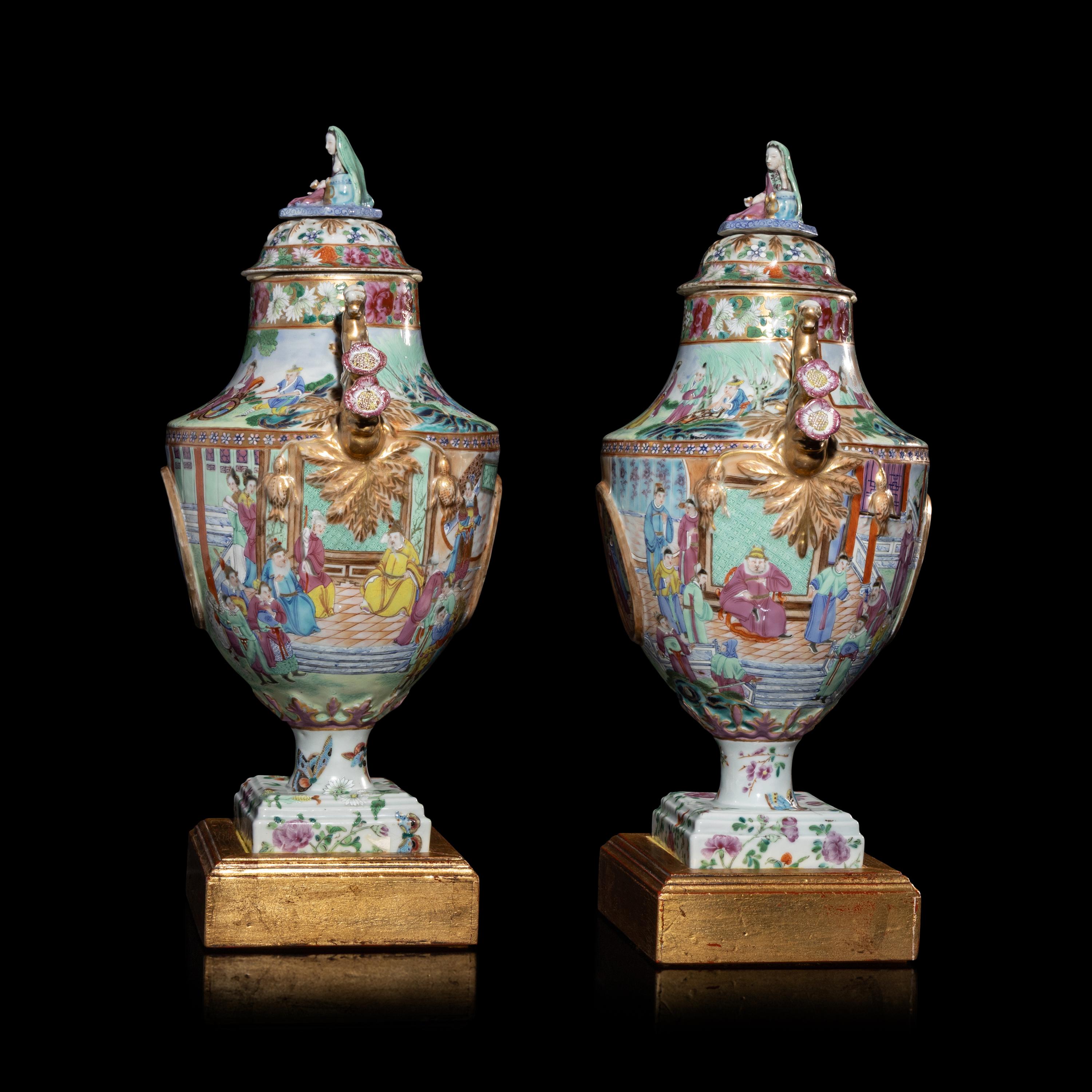 A Pair of Chinese Export Canton Famille Rose Porcelain Covered Urns, Early 19th Century — 清晚期 外銷廣彩人物故事圖獎杯形賞瓶一對