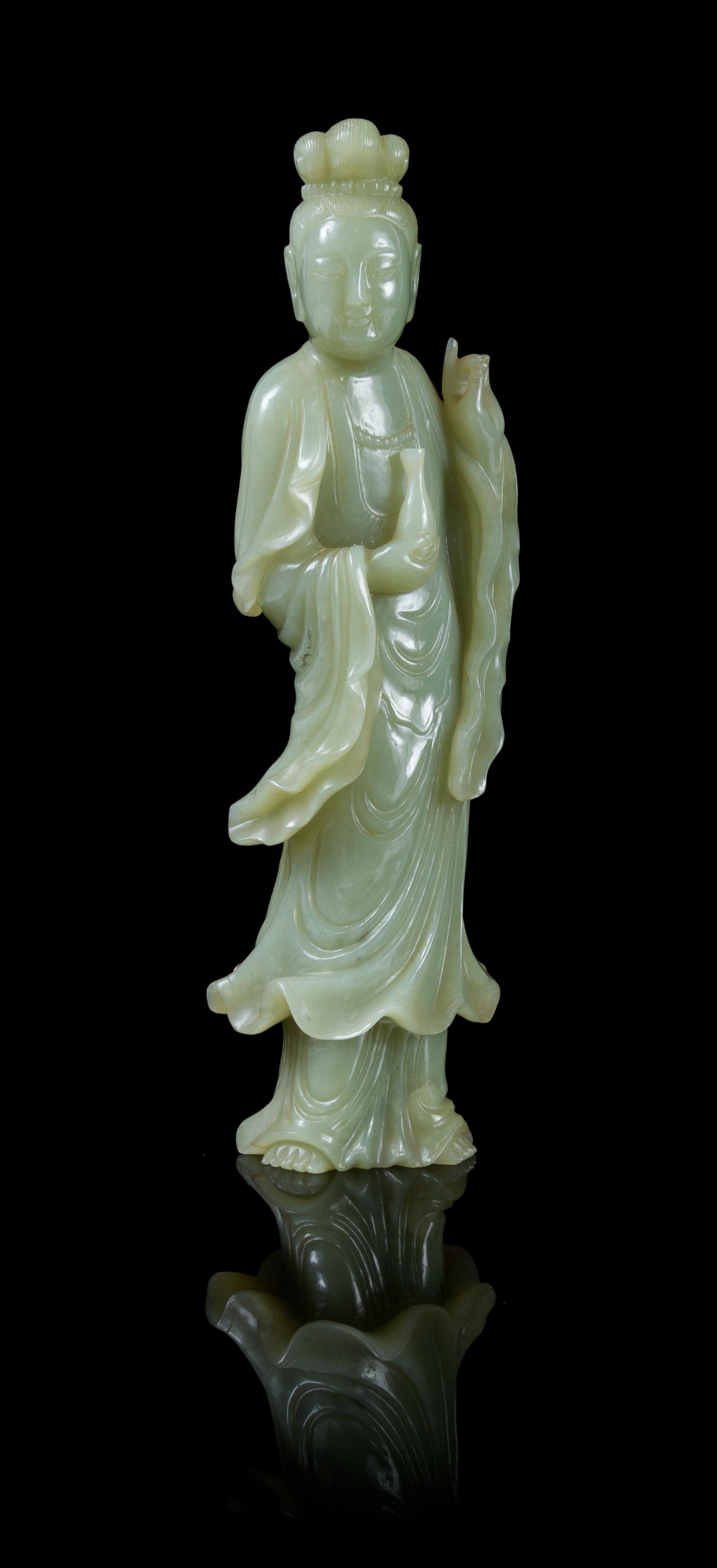 A Celadon Jade Figure of Guanyin POSSIBLY 19TH CENTURY Height 9 inches. — POSSIBLY 19TH CENTURY