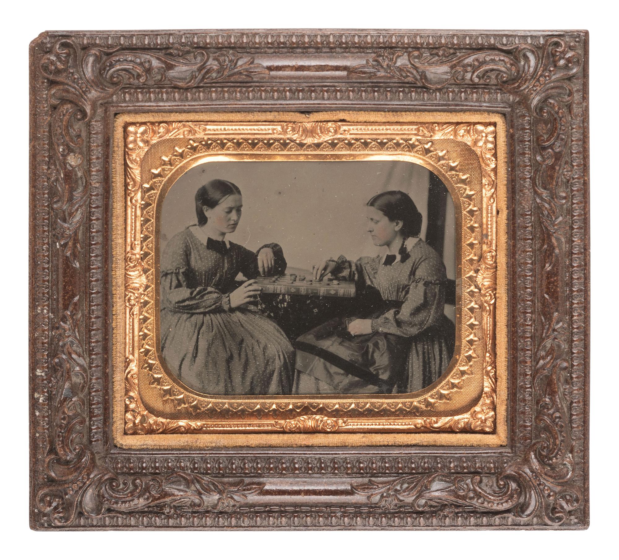 [EARLY PHOTOGRAPHY]. Sixth plate tintype of identified women engaged in a game of checkers. Ca 1863.