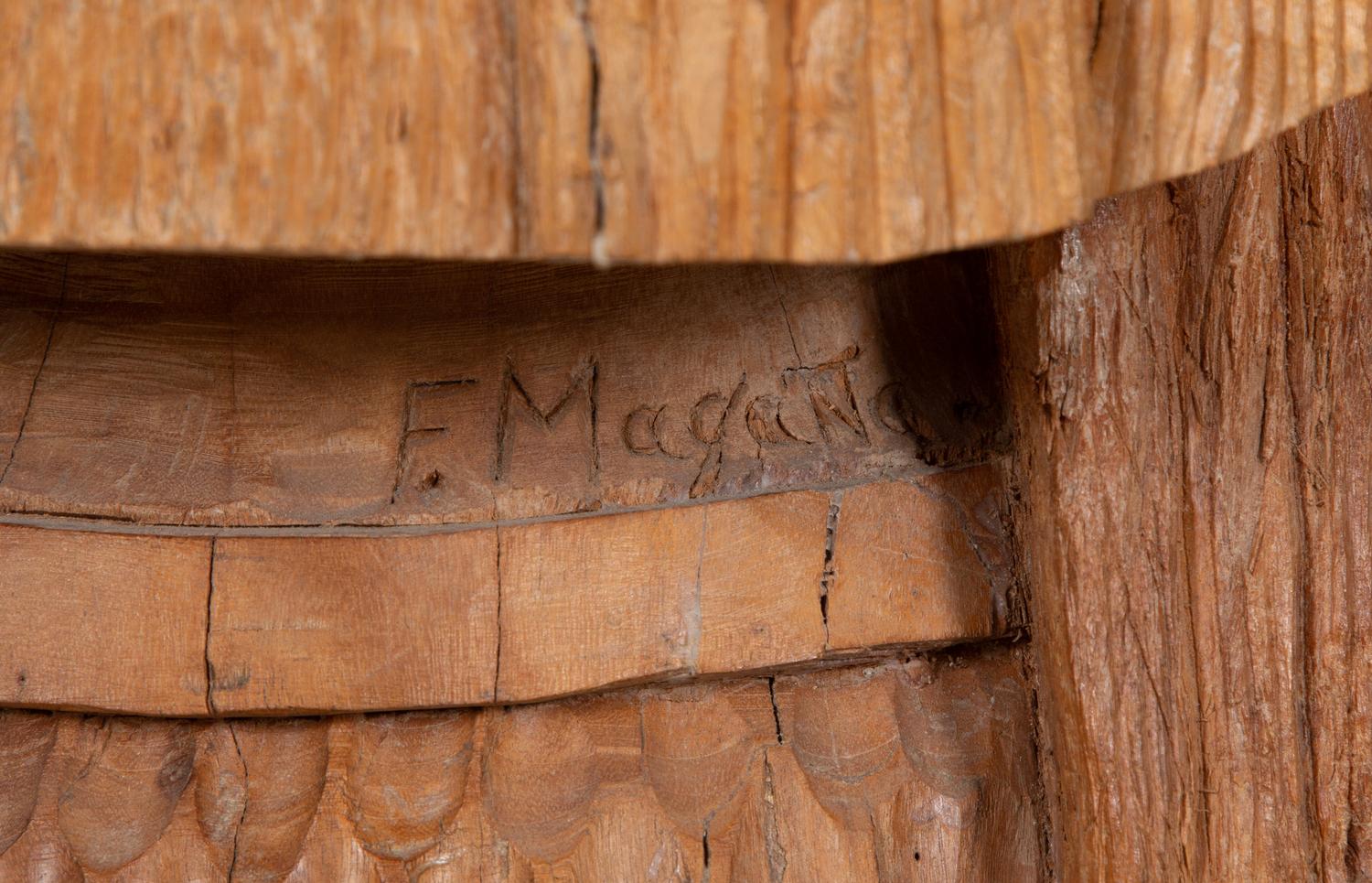 A Carved Wood Sculpture of a Three-Faced Man