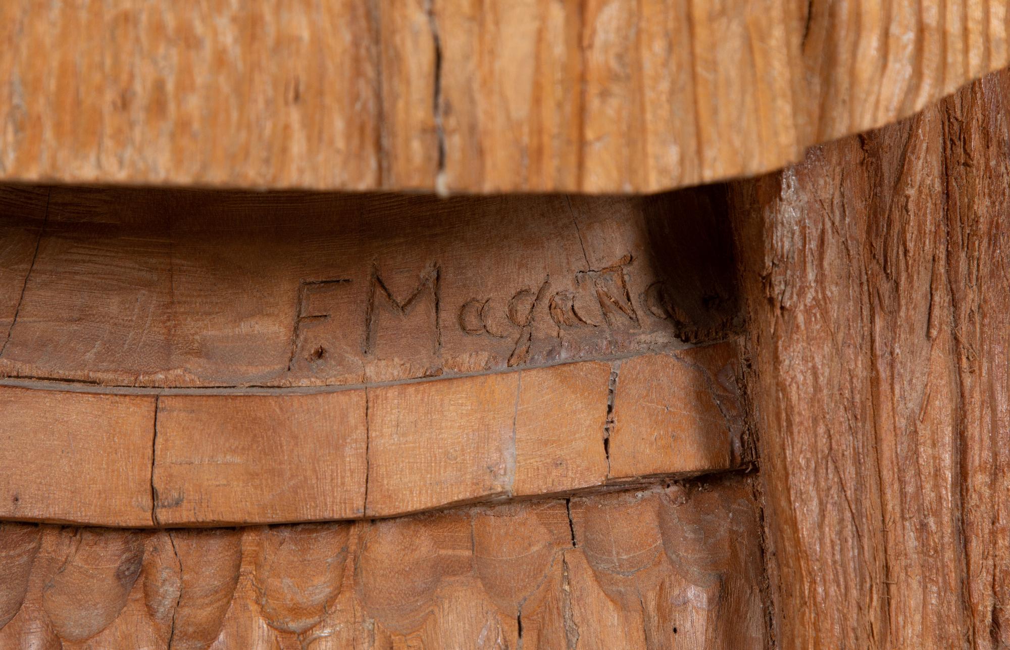 A Carved Wood Sculpture of a Three-Faced Man