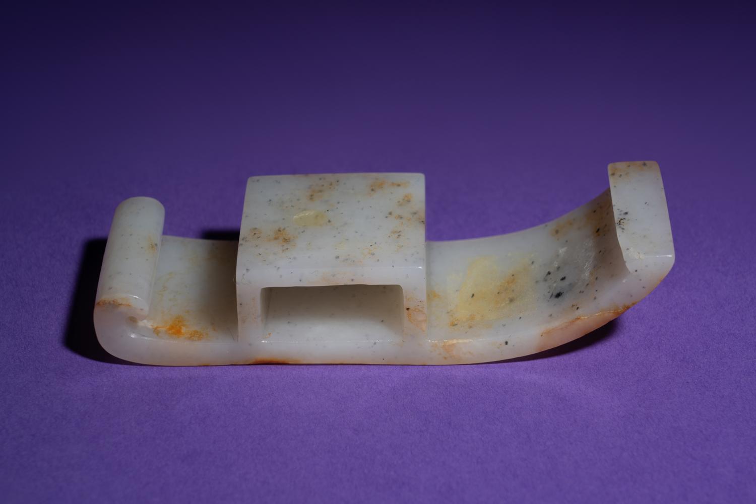 A Chinese White and Russet Jade Sword Slide, Jianzhi