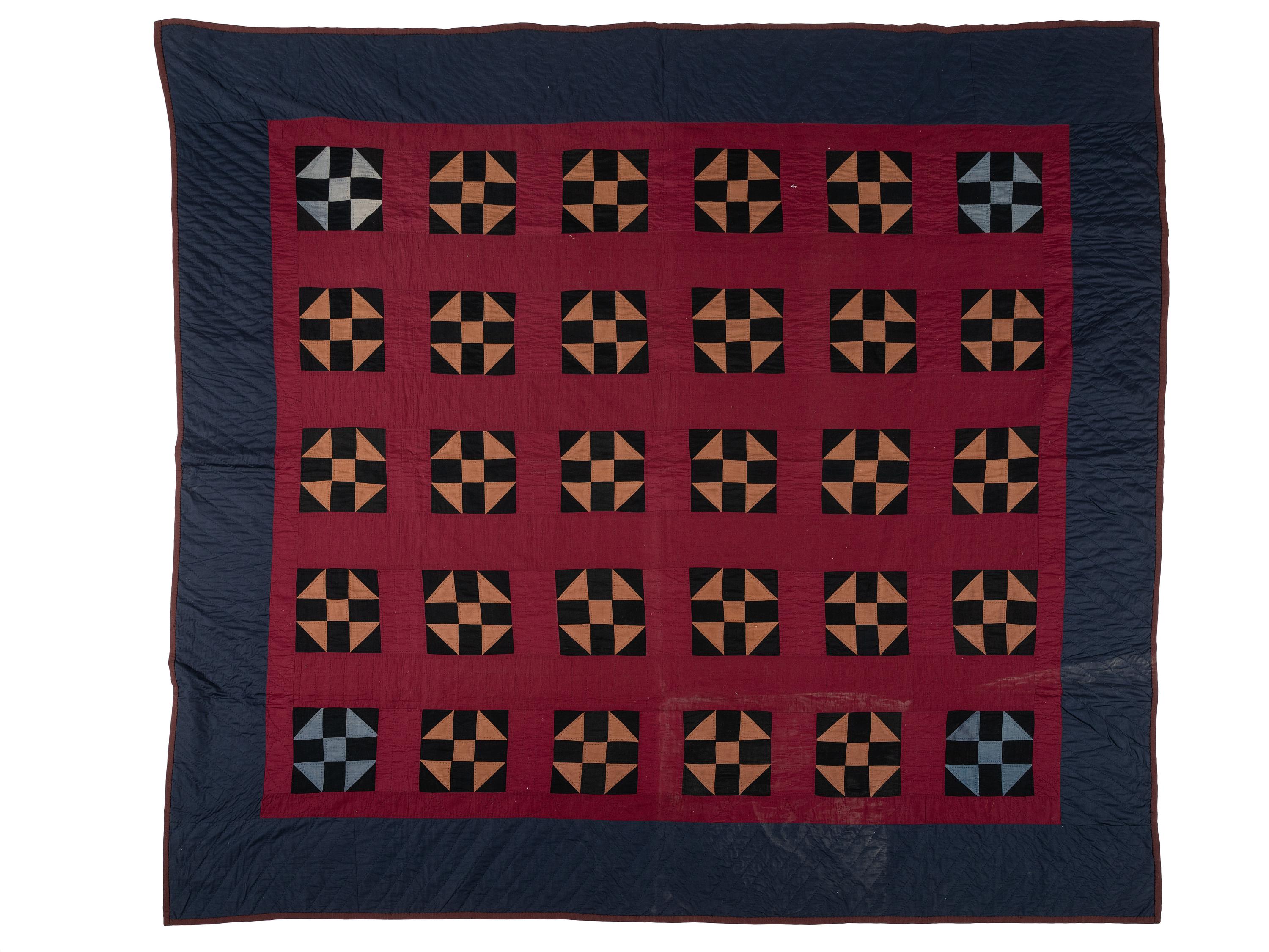 A Red, Orange, Black and Navy Blue Pieced Cotton Quilt