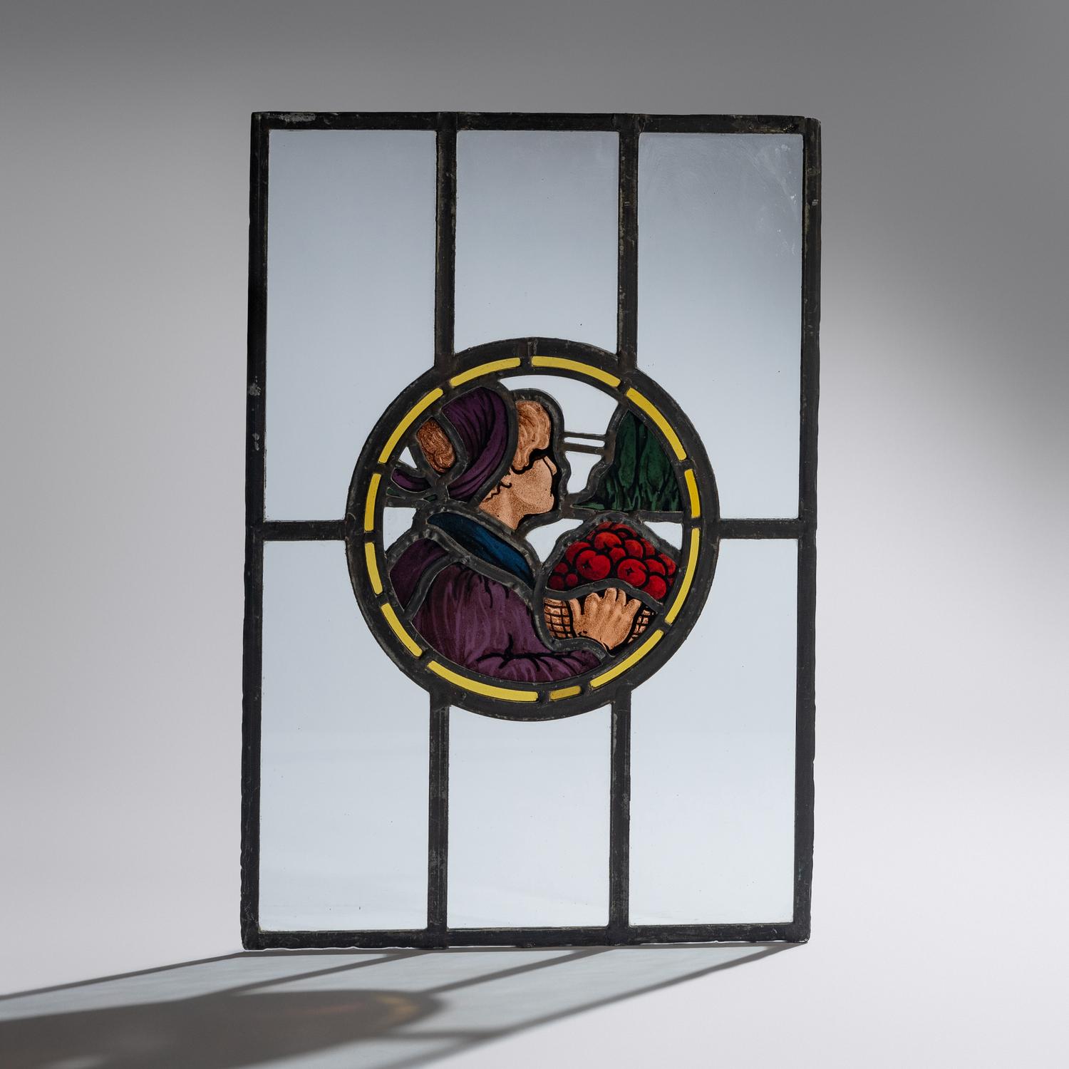 Stained glass window depicting man with basket of apples