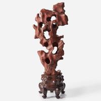 A Chinese scholar's rock on wood stand, possibly red Taihu stone