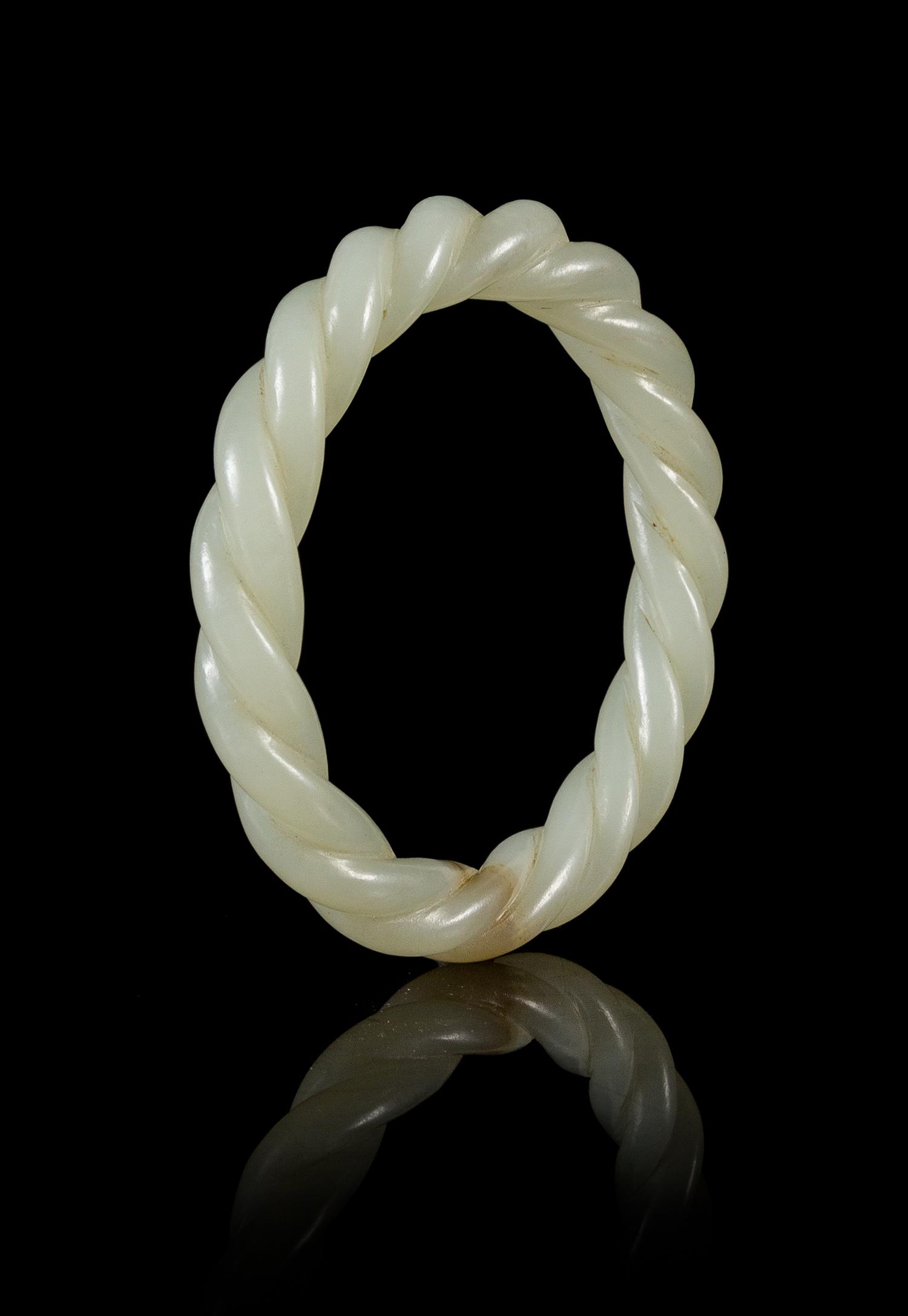 A Carved Celadon Jade 'Robe Twist' Bangle Diameter 3 inches. — 19TH/20TH CENTURY