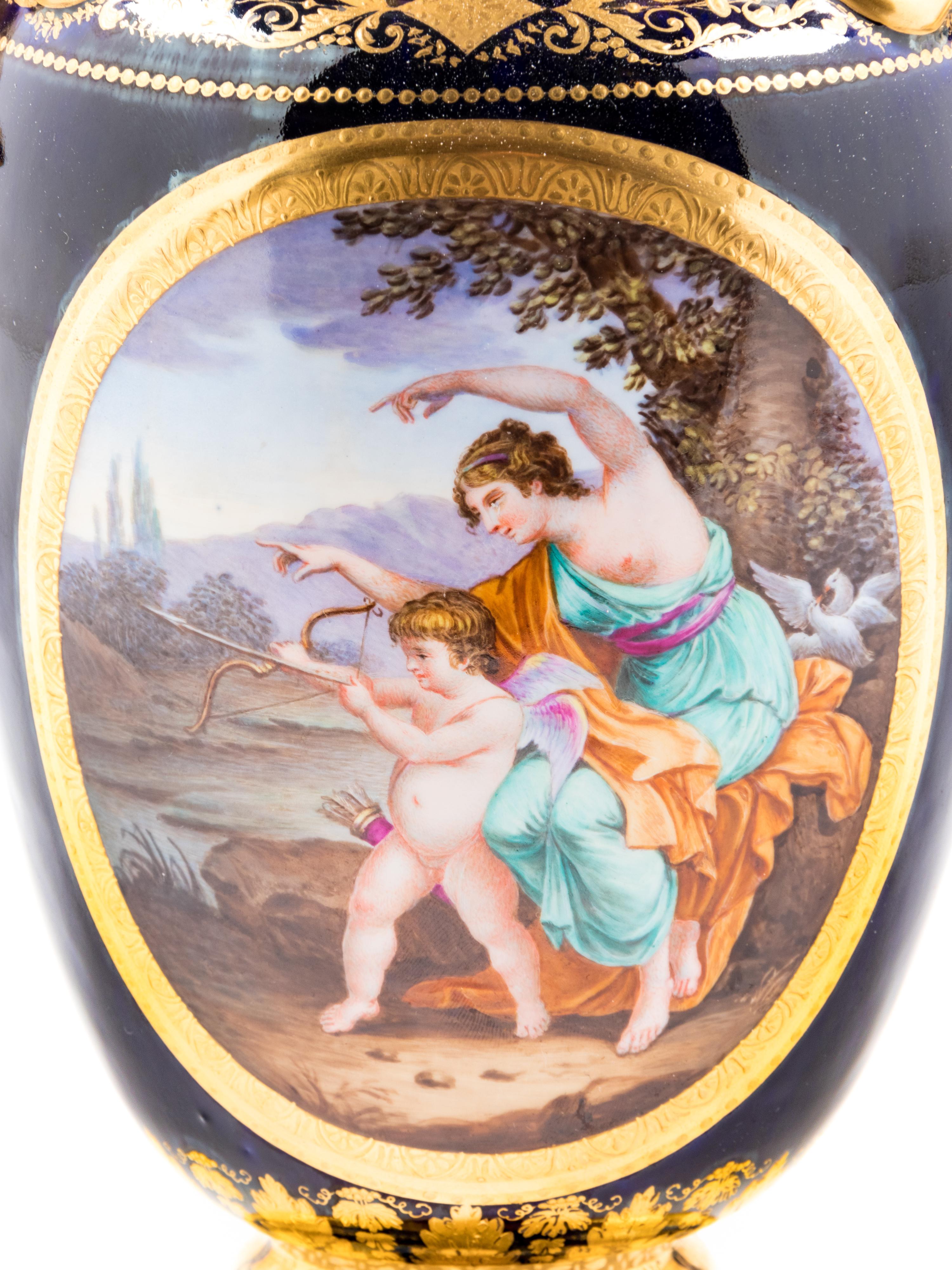 A Pair of Vienna Painted and Parcel Gilt Handled Porcelain Urns