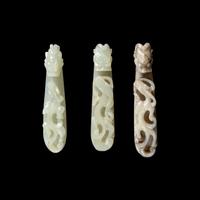 A Chinese 'Chicken-Bone' Jade and Two Pale Celadon Jade 'Dragon' Belt Hooks, Qing Dynasty 清 玉龍鉤三件