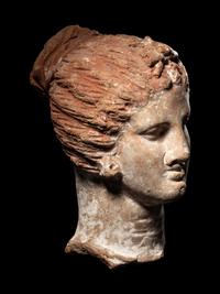 A Greek Terracotta Female Head with a Melon Coiffure