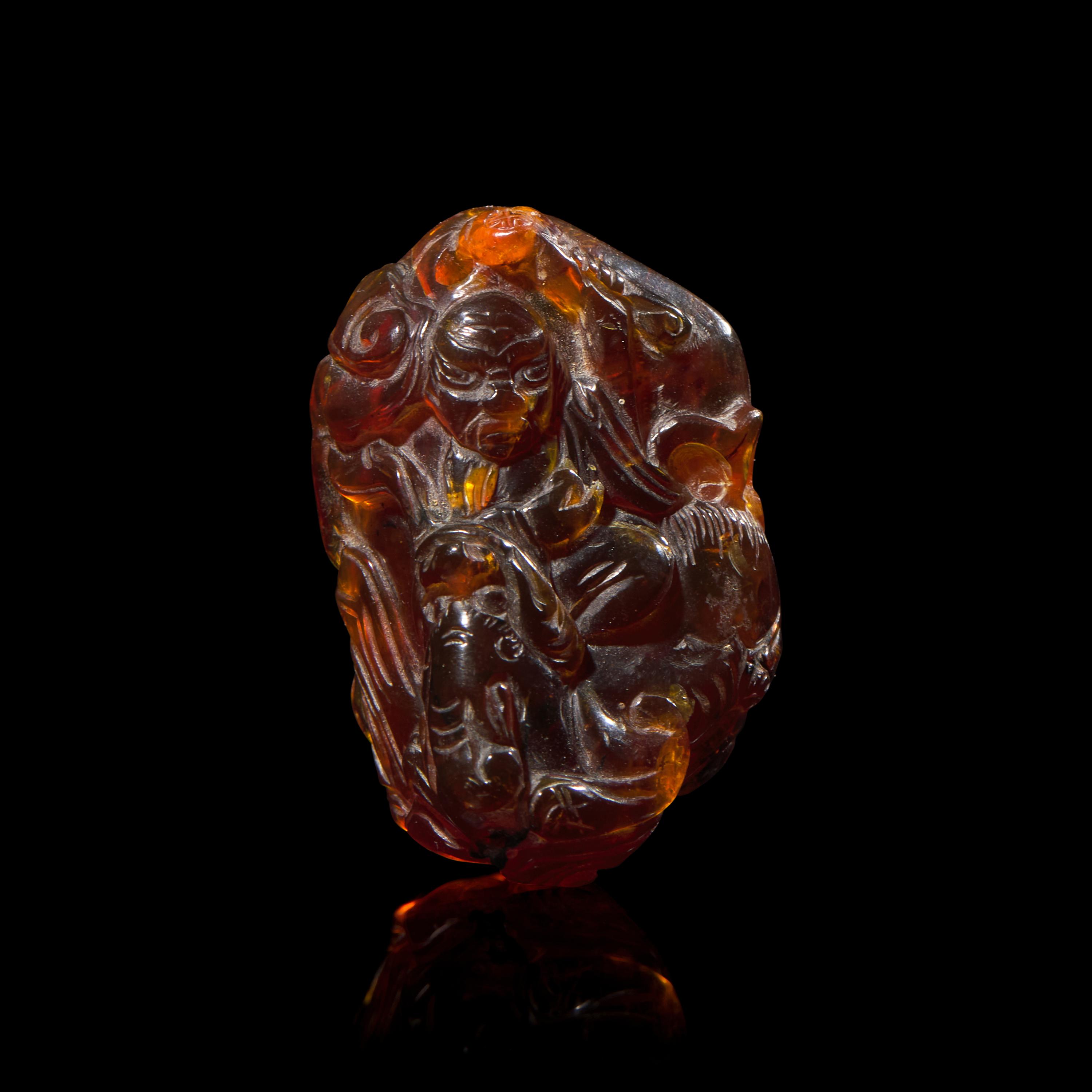 A Chinese Carved 'Bats and Shou-Lao' Amber Pendant, 18th-19th Century 清中期 五福捧壽琥珀把件