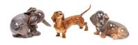 A Group of Three Dachshund Porcelain Figures Width of widest 5 1/8 inches.