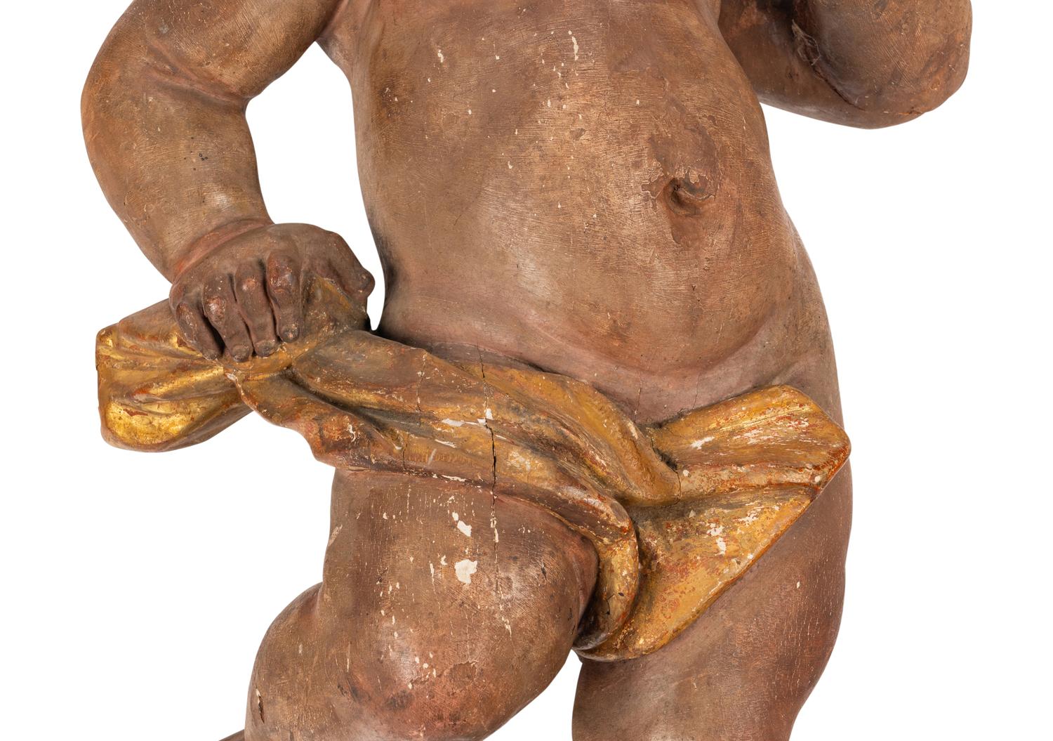 A Painted and Parcel Gilt Wood Figure of a Putto