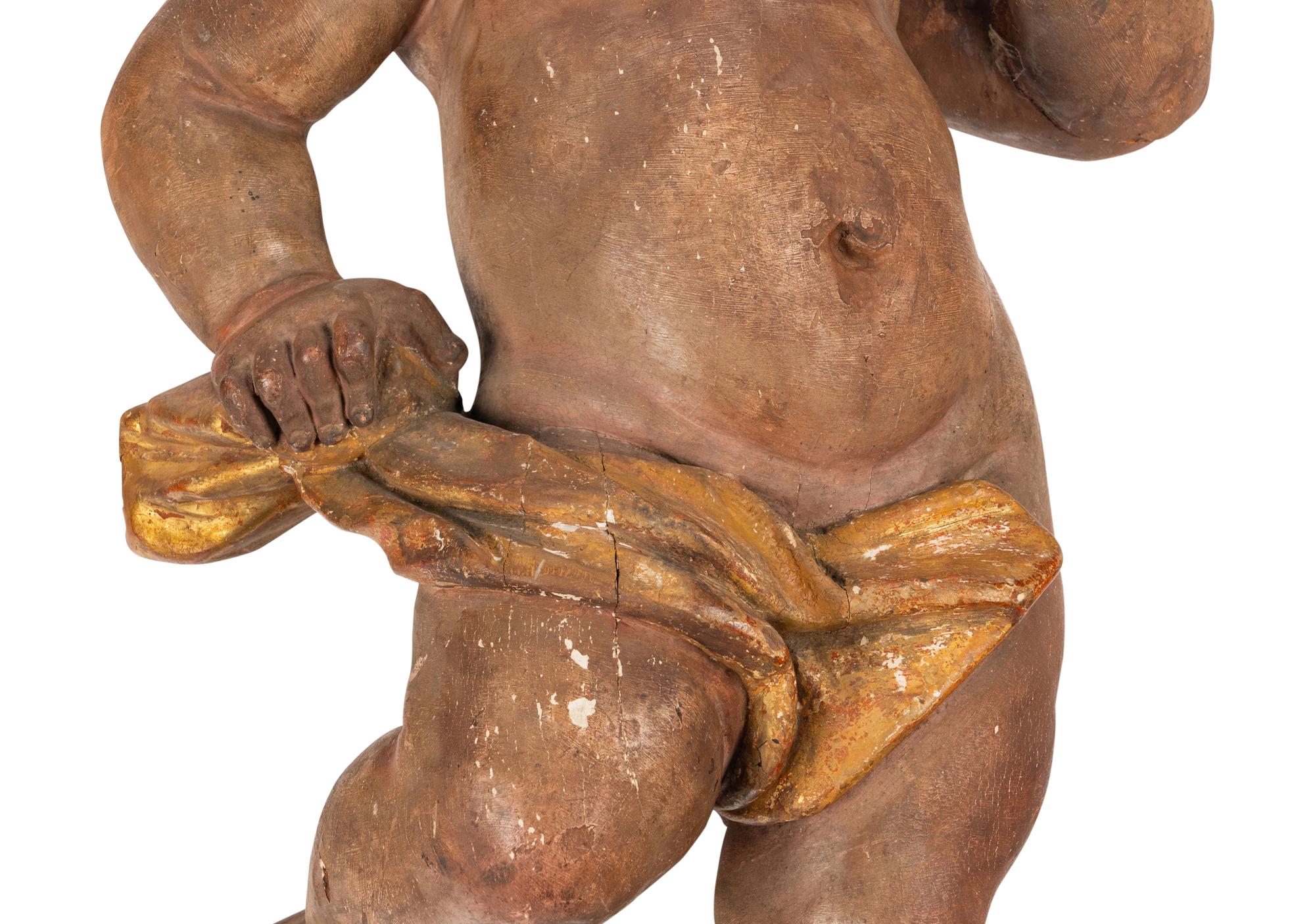 A Painted and Parcel Gilt Wood Figure of a Putto