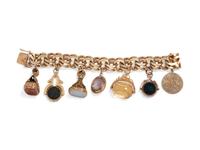 A 14 Karat Yellow Gold Bracelet With Seven Attached Fobs and Charms,