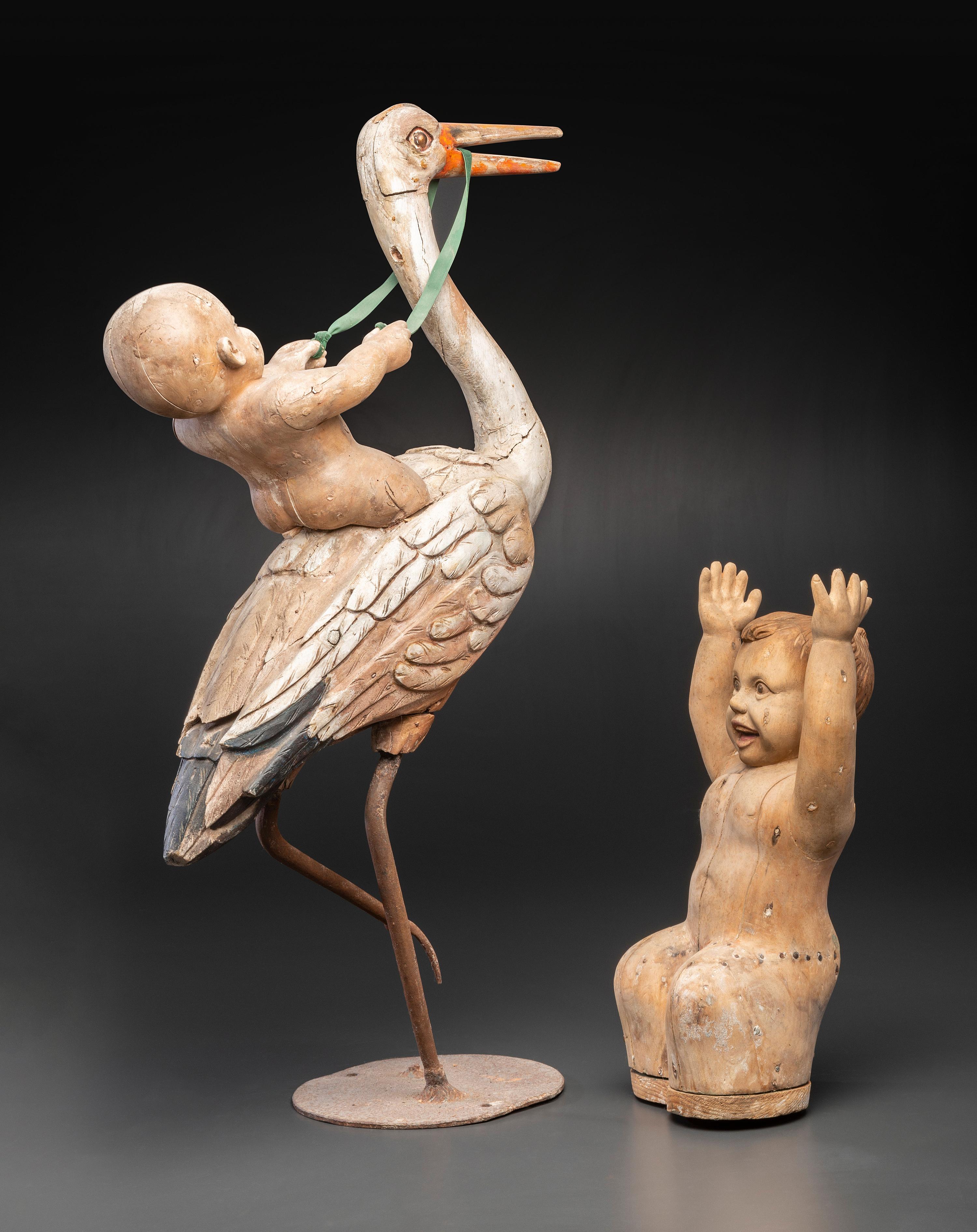 A Folk Art Carved and Painted Wood Figural Group of a Stork and Two Babies