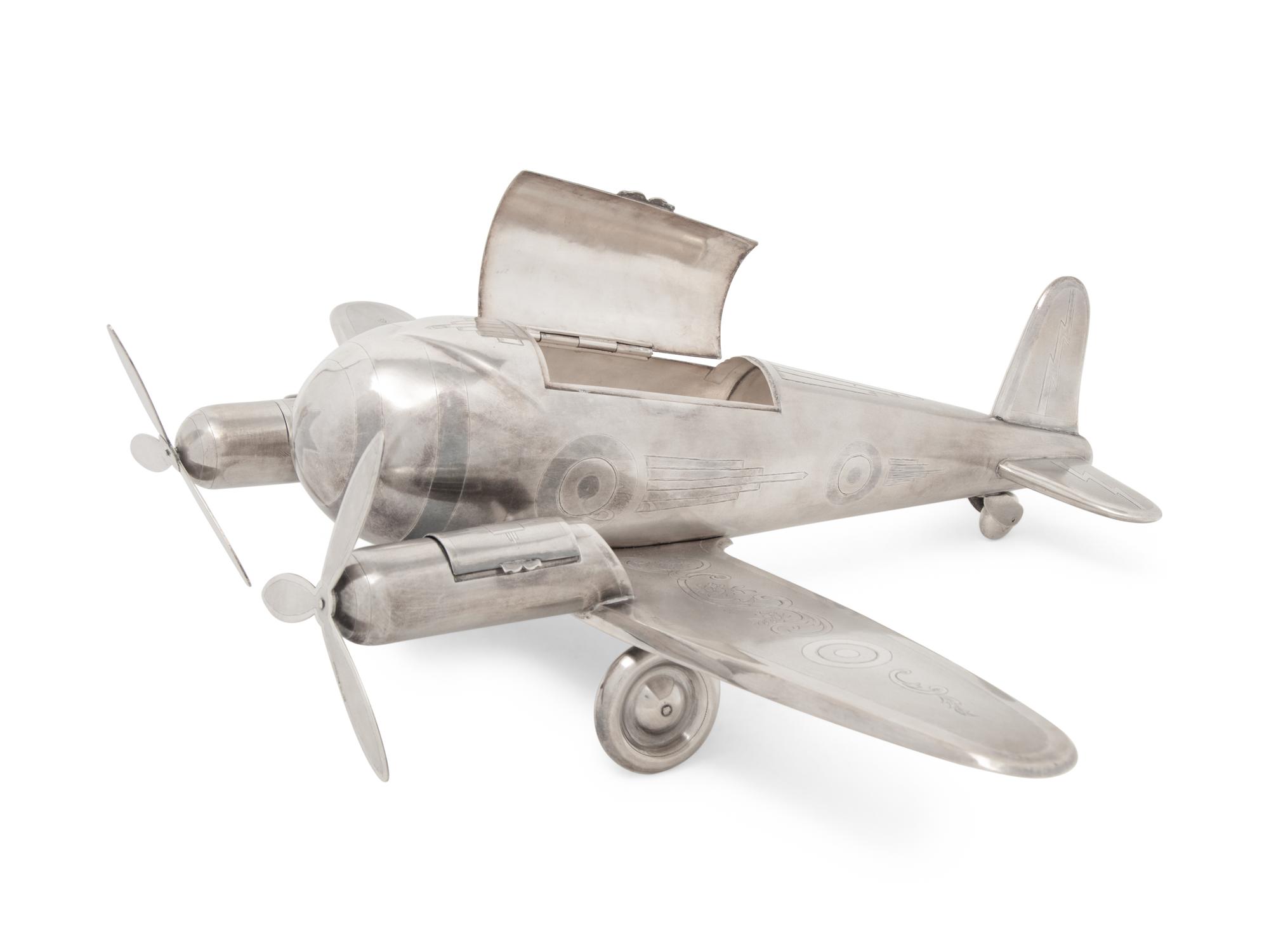 A Large Silvered Metal Airplane-Form Table Top Smoking Set