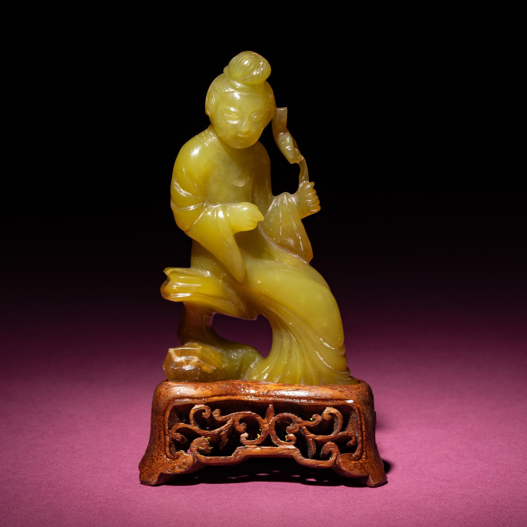 A Chinese Yellow Jade Seated Figure of a Lady, Late Qing Dynasty — 清晚期 黃玉持蓮仕女