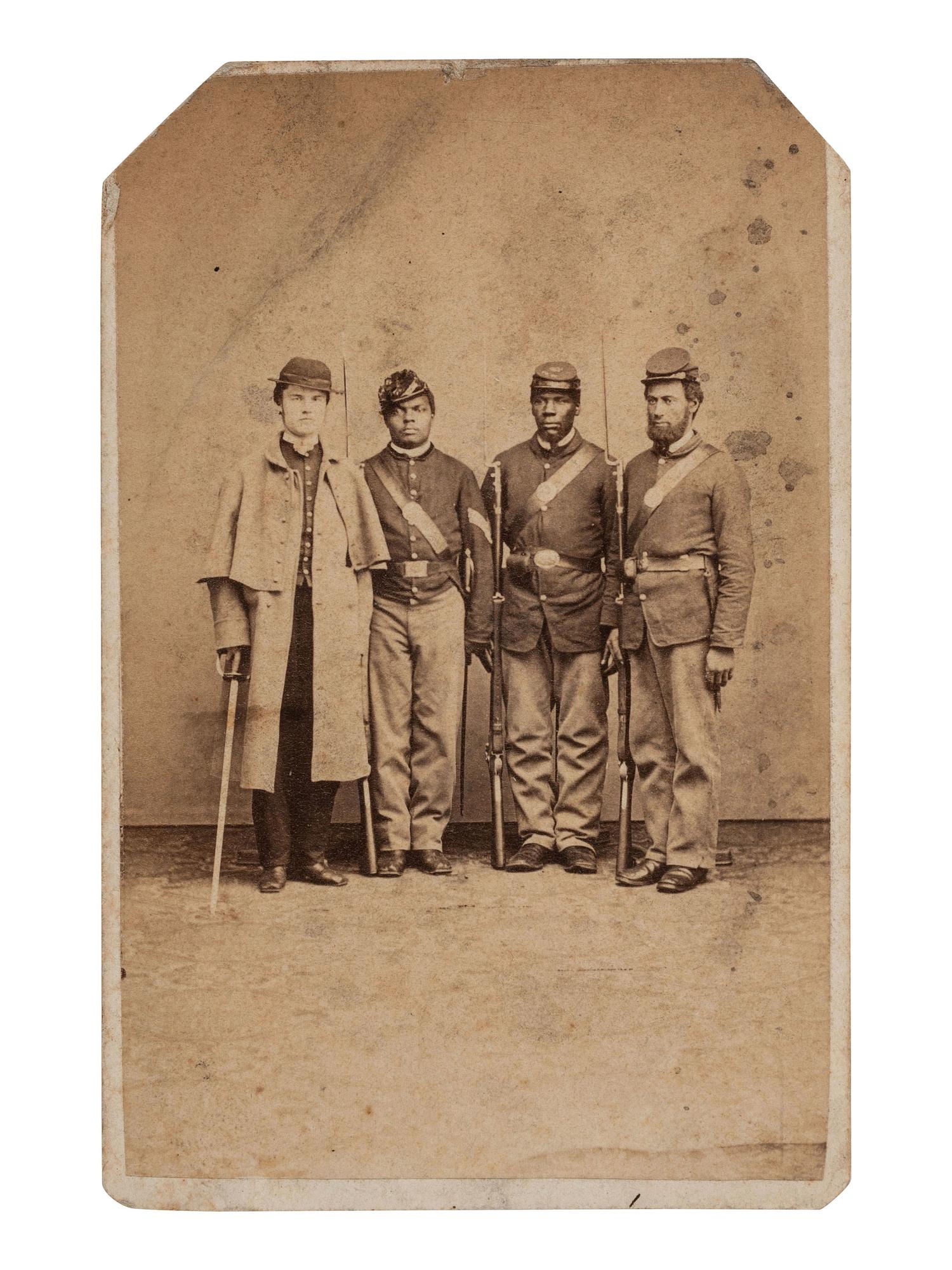 [CIVIL WAR]. CDV of an African American sergeant and private posed with white soldiers in a studio. Philadelphia, PA: O.H. Willard, ca 1864-1865.