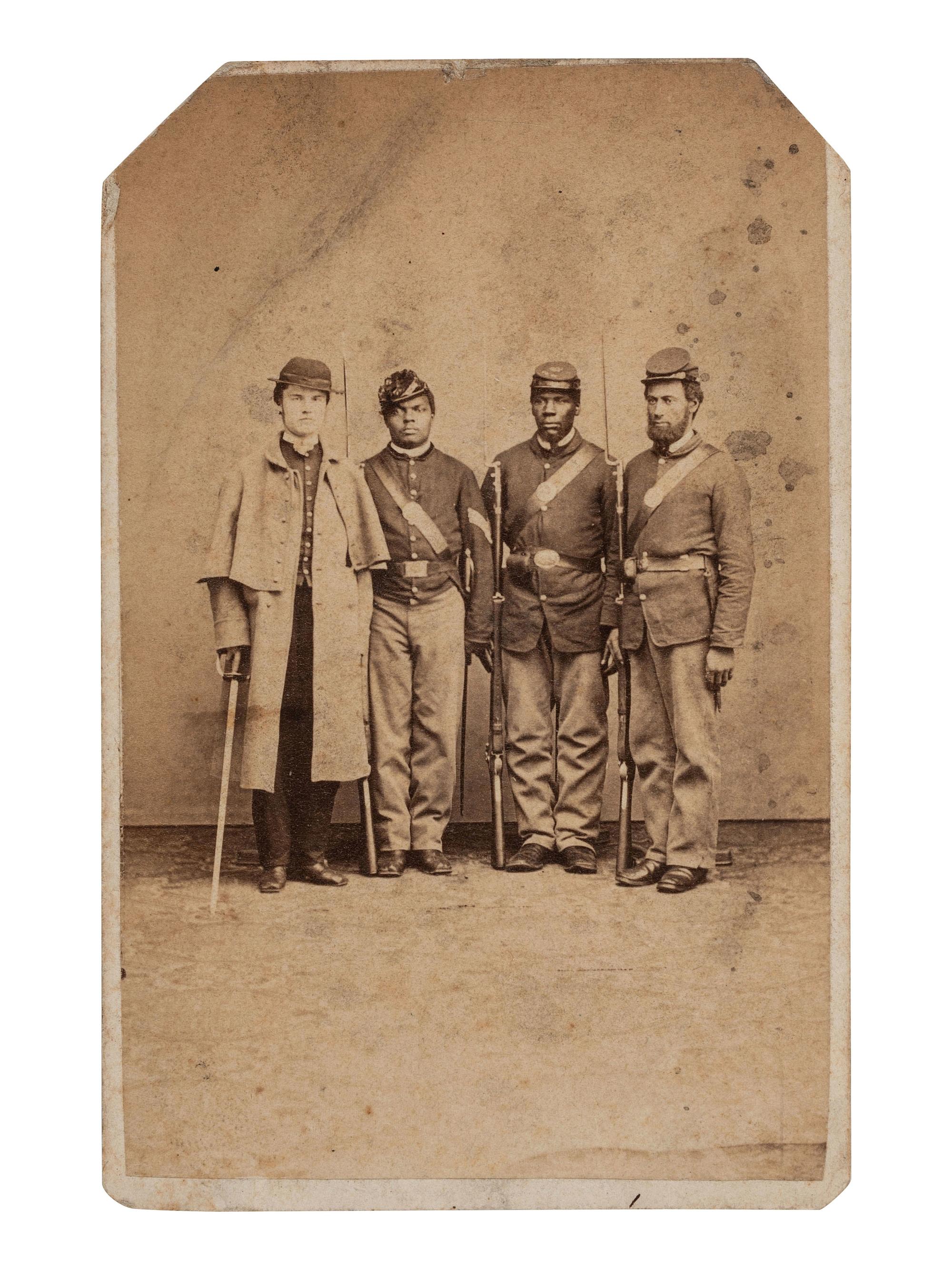 [CIVIL WAR]. CDV of an African American sergeant and private posed with white soldiers in a studio. Philadelphia, PA: O.H. Willard, ca 1864-1865.