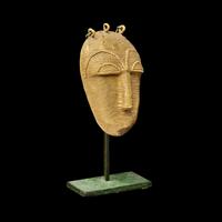 A Lagoons Region Gilt-Brass Mask Pendant
