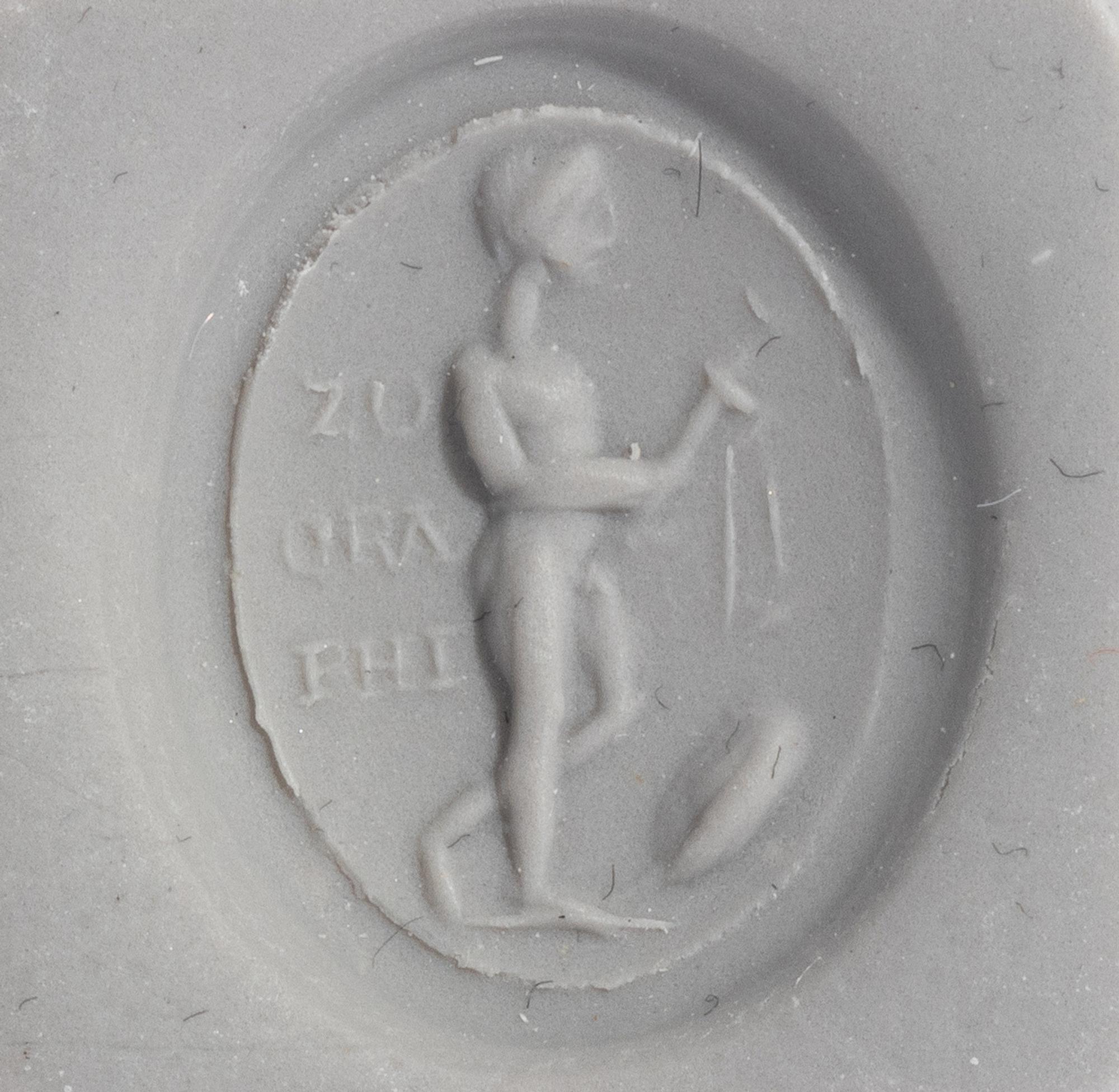 A Roman Gold and Plasma Finger Ring with a Figure Holding Tools and an Inscription