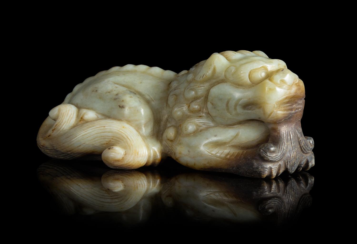 A Carved Celadon Jade Figure of a Recumbent Lion Length 4 3/4 inches.