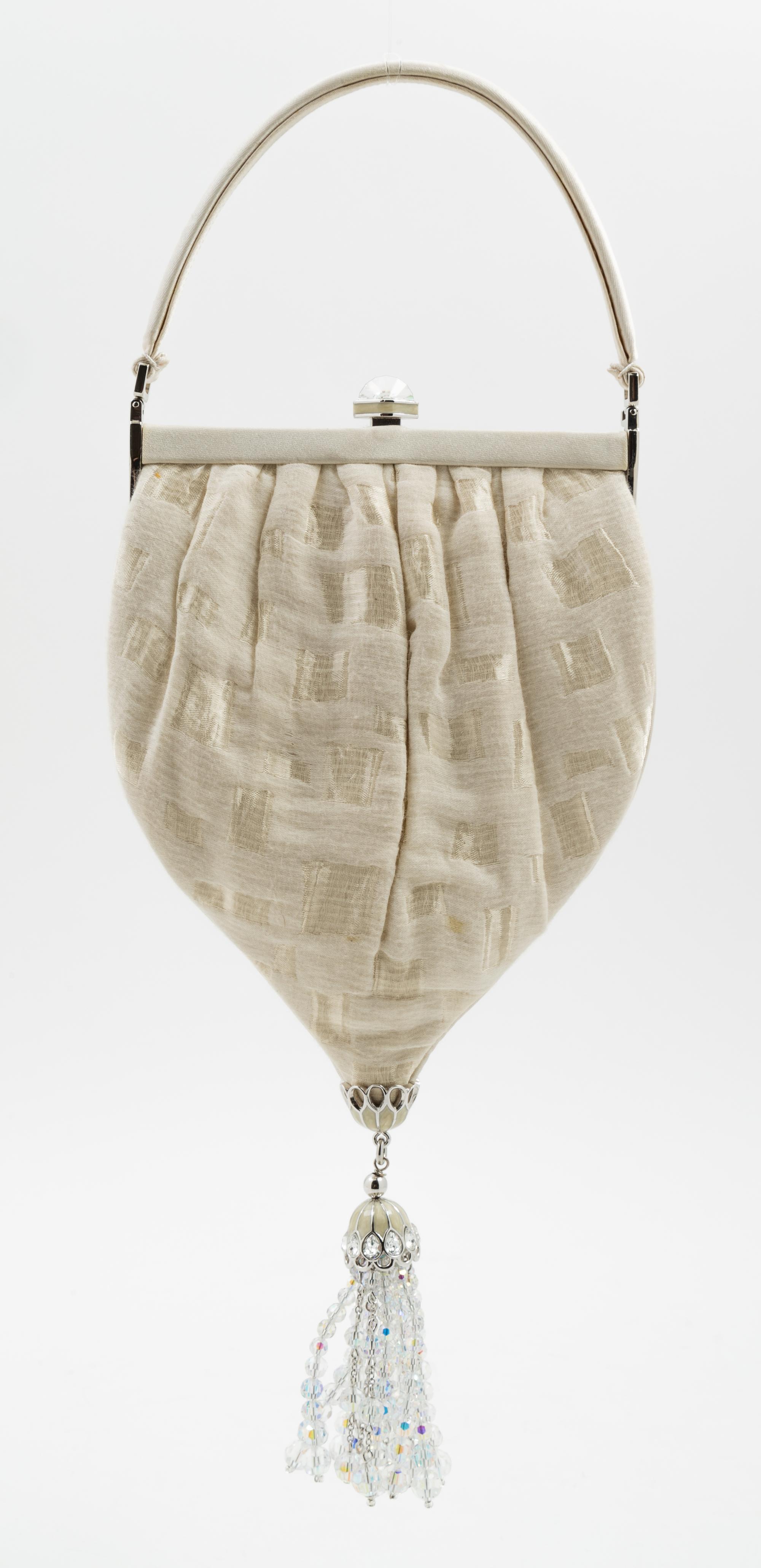 A Judith Leiber Cream Silk Textured Handbag, 5.5" x 10" x 1"; Handle drop: 3".